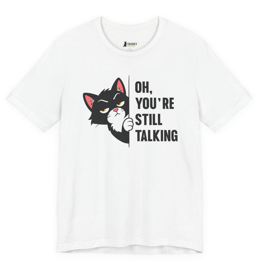 Funny cat t-shirt with Oh You’re Still Talking slogan and black peeking cat graphic on white shirt