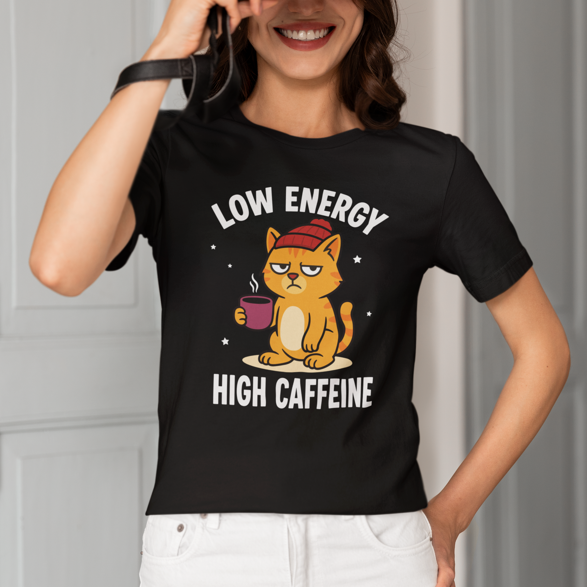 Model wearing Low Energy High Caffeine Beanie Cat T-Shirt with coffee cat graphic design